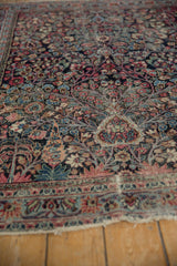 Worn floral branches and intricate buds on vintage Persian Meshed rug with tattered fringe.
