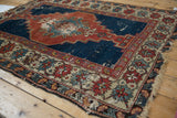 Shirvan rug border with madder red and ivory floral motifs, worn cobalt blue field.