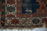 Antique Shirvan rug corner: threadbare cobalt blue field, madder red floral border, tattered fringe.