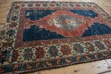 Worn, wide main border of antique Shirvan rug, with interconnected red and teal floral motifs.