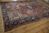 Vintage Heriz rug side view with navy samovar border and ivory fringe.