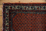 Engelas rug corner: madder rust field with staggered botehs, ivory vine border, worn edge.