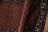 Hand-knotted pile texture of the vintage Engelas rug, showing madder rust field and blue botehs.