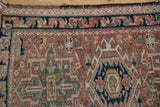 Hand-knotted vintage Karaja rug texture detail with geometric field patterns in faded dusty rose and navy.