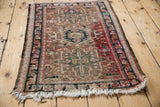 Intact dark selvage framing the navy border and geometric red field of a Karaja rug.