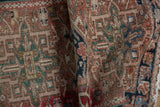 Vintage Karaja rug showing hand-knotted geometric motifs in dusty rose, navy, forest green hues.