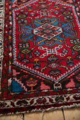 Vintage Borchalou rug detail reveals hand-knotted pile, sapphire blue floral motifs, and structured side border.