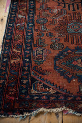 Vintage Lilihan rug border detail: sapphire blue and raspberry red patterns, with tattered edge.