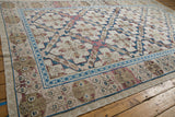 Distressed Turkish Soumac carpet: sapphire blue geometric border, ivory field, and floral medallions.