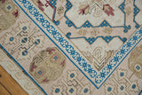 Distressed Turkish Soumac carpet corner: hand woven ivory, blush, sapphire blue patterns.