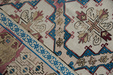 Distressed Turkish Soumac carpet detail with ivory, sapphire blue, and dusty red geometric patterns.