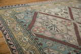 Distressed Turkish Soumac rug with sand, blue, pink plant motifs and wave border.