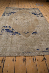 Textured pile of a distressed Oushak rug, revealing worn cobalt blue and sand tones.