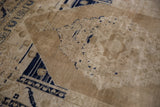 Heavy abrashes revealing faded beige pile and cobalt blue motifs on a vintage Oushak rug.