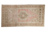 Vintage distressed Oushak rug with a hexagonal center medallion in soft pink, beige, and pale coffee brown.