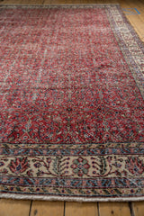 Distressed Turkish Sparta carpet texture with cherry red field, delicate vinery, and patterned border.