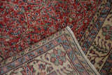 Distressed Sparta rug corner: worn cherry red field, intricate beige border motifs, and fringe.