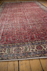 Distressed cherry red field with delicate vinery and ivory floral border of a vintage Sparta rug.