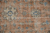 Distressed vintage Sparta carpet pile, showing floral palmette vinery in sandstone, ivory, and blue.