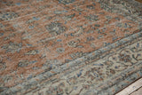 Distressed sandalwood field texture with delicate blue palmettes and vinery scrolling.