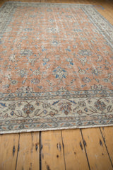 Distressed vintage Sparta carpet with ivory fringe and subtle floral border details.