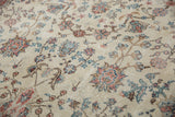 Ivory distressed Sparta carpet with pink and blue blossoms, vinery, and visible pile wear.
