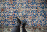 Distressed vintage Sparta carpet, sky blue field with terracotta florals and visible foundation.