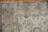 Corner of distressed Sparta carpet, showing worn lotus flowers, vinery in ivory, apricot, jade.