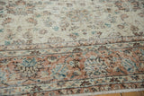 Distressed Sparta rug with ivory and apricot floral pattern, revealing foundation.