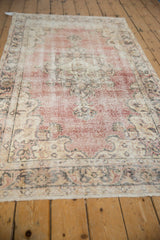 Distressed vintage Sparta runner section, with faded cochineal red and ivory floral palmette motifs.
