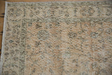 Distressed Sparta rug corner showing muted spiral vine motifs and meandering border.