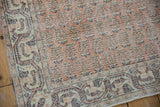 Distressed Vintage Sparta rug corner, with worn germinating flower motifs and an ivory, navy, melon border.