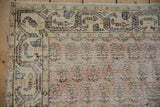 Distressed Sparta rug corner, showing melon, ivory germinating flowers, and wear.
