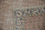 Distressed Sparta rug with worn pale melon pile, allover flowers, and intact selvedge.