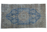 Vintage distressed Sparta rug runner, hand knotted, with faded blue and ivory floral medallion.