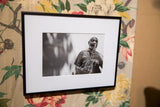 Angled view of The Sax Man photograph, showing its slim black frame and white matting.