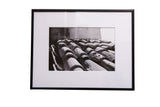 A contemporary black and white photograph of textured terracotta tiles, matted in a black frame.