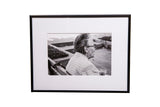 The Chatter framed black and white portrait of a woman seated on a bench, 5x8.