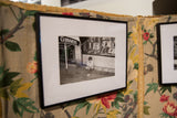 Black framed black and white photograph featuring a Guinness sign and shop window details.