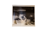 Black and white photograph print of a still life scene featuring a praying bust.