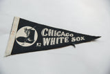 Stitched felt edge and baseball player graphic on a vintage Chicago White Sox pennant with patina.