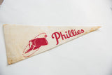 Red Phillies team name and baseball cap graphic on aged cream felt pennant.