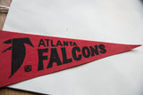 Angled detail of the vintage Atlanta Falcons pennant showing the black text and logo on red felt.