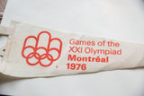 Red Montreal 1976 Olympiad logo and text on the vintage pennant's white felt.