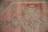 Vintage Distressed Oushak runner's abrashed pile with dusty rose and stepped motifs.