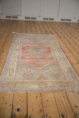 Distressed Oushak runner border featuring faded gold, blush, mint, and mauve patterns.