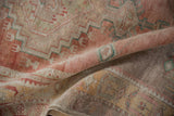 Distressed hand-knotted Oushak runner pile in faded blush, raspberry, and sea foam green.