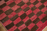 Heavy abrashes and coarse pile of the vintage Tulu rug's red and brown checkered motif.