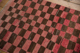 Distressed checkerboard Tulu rug pattern in dusty cochineal and chocolate brown.