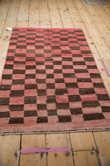 Distressed Tulu rug's nuanced checkered pattern in cherry red and chocolate brown.